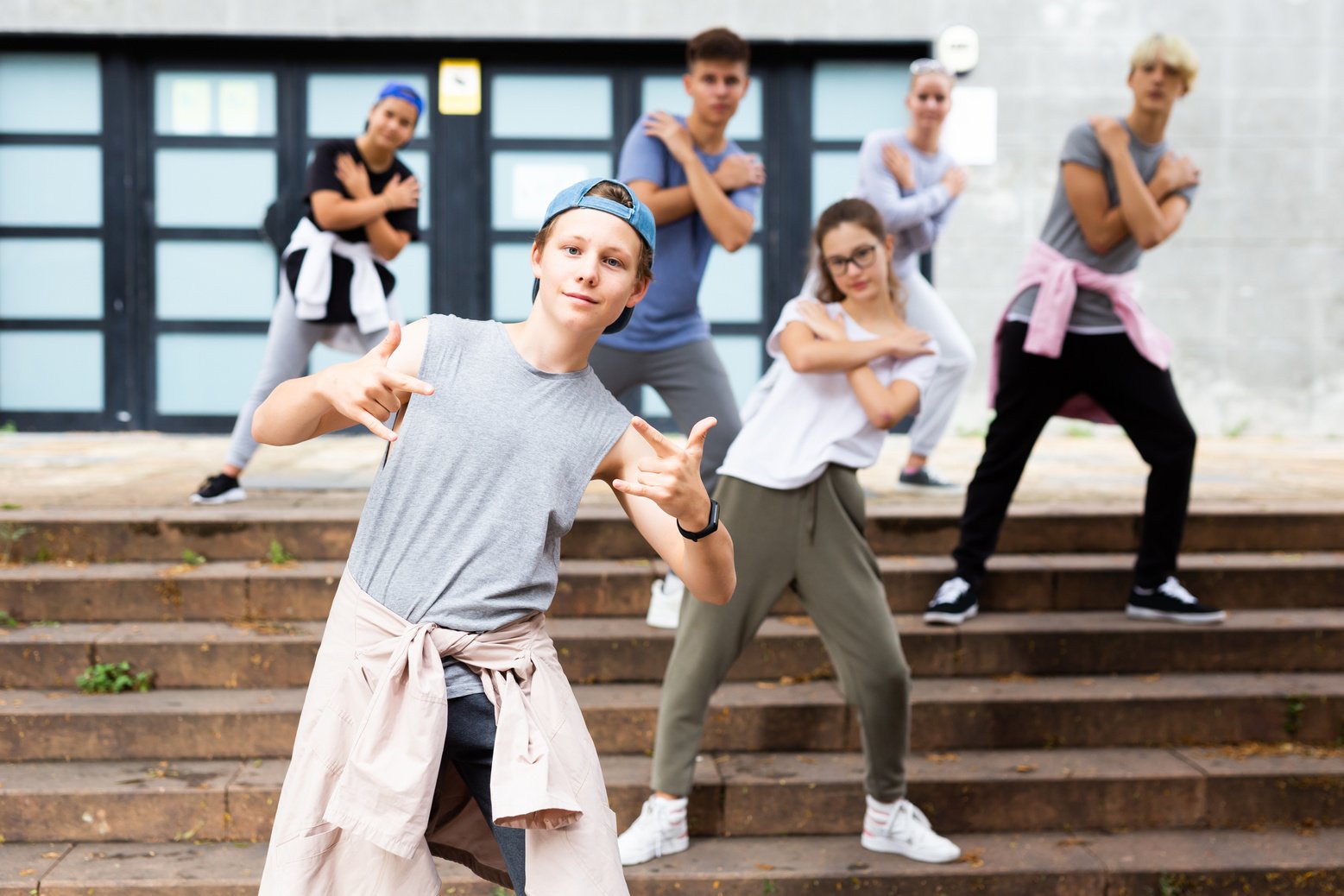 Teen boy dancing modern street dance with teenagers